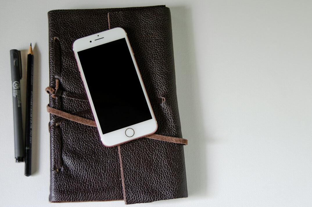 Smartphone and notebook on a desk ready for contact